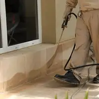 General pest control technician spraying exterior perimeter around a home in Las Vegas, NV
