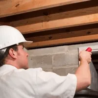 Termite inspection technician checking a basement wall and framing for termite activity in Las Vegas, NV