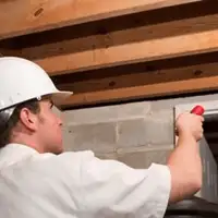 Termite inspection technician checking a basement wall and framing for termite activity in Las Vegas, NV